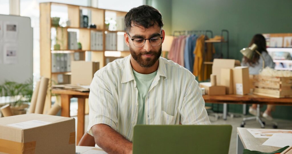 Tailor, man and laptop in small business for order, inventory check and stock at sme. Shipping, com